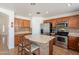 Kitchen island featuring an eat-in counter, stainless steel appliances, and ample cabinet space at 9352 W Pioneer St, Tolleson, AZ 85353