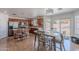 An open kitchen features wood cabinets, an island with bar seating, and adjacent dining area with backyard access at 9352 W Pioneer St, Tolleson, AZ 85353