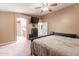 Comfortable main bedroom featuring neutral tones, soft carpet, a ceiling fan, and ensuite bathroom at 9352 W Pioneer St, Tolleson, AZ 85353