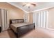 Relaxing main bedroom features neutral tones, soft carpet, a ceiling fan, and large bed for comfortable living at 9352 W Pioneer St, Tolleson, AZ 85353