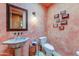 Unique bathroom with a stone pedestal sink, decorative mirror, and earth-toned walls, creating a rustic and elegant space at 9415 N 124Th St, Scottsdale, AZ 85259