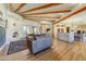 Expansive living room showcasing wood beam ceilings, a cozy fireplace, and an open layout leading to the kitchen at 9415 N 124Th St, Scottsdale, AZ 85259