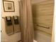 Bathtub with tile surround and a shower curtain, complemented by a towel rack with neutral-colored towels at 9679 W Cinnabar Ave # B, Peoria, AZ 85345