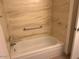 Bathroom featuring a bathtub with tiled walls and updated fixtures at 9679 W Cinnabar Ave # B, Peoria, AZ 85345
