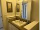 This bathroom features tile countertops, an integrated sink, and a neutral color scheme at 9679 W Cinnabar Ave # B, Peoria, AZ 85345