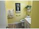 Compact bathroom featuring a sink, toilet, grab bar, neutral tile, and a bright yellow wall color at 9679 W Cinnabar Ave # B, Peoria, AZ 85345