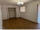 Bedroom with hardwood floors, a closet, and two windows, creating a comfortable living space at 9679 W Cinnabar Ave # B, Peoria, AZ 85345