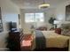 Bedroom featuring a plush bed, dresser, side tables, chair, and bright natural lighting at 9679 W Cinnabar Ave # B, Peoria, AZ 85345