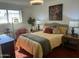 Bright bedroom featuring a bed, side tables, a dresser, an accent chair and sunny natural light at 9679 W Cinnabar Ave # B, Peoria, AZ 85345
