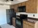 Kitchen featuring wooden cabinets, black appliances, and ample counter space at 9679 W Cinnabar Ave # B, Peoria, AZ 85345