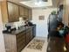 Well-lit kitchen featuring wood cabinets, black appliances, a double basin stainless steel sink, and a skylight above at 9679 W Cinnabar Ave # B, Peoria, AZ 85345