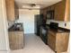 Functional kitchen with wood cabinets and modern black appliances at 9679 W Cinnabar Ave # B, Peoria, AZ 85345