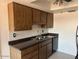 Kitchen with wood cabinets, dark countertops, and a stainless steel sink at 9679 W Cinnabar Ave # B, Peoria, AZ 85345