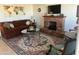 Cozy living room featuring a decorative brick fireplace, large area rug, comfortable seating and stylish decor at 9679 W Cinnabar Ave # B, Peoria, AZ 85345