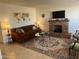 Spacious living area with a brick fireplace, comfortable seating, area rug, and decorative artwork at 9679 W Cinnabar Ave # B, Peoria, AZ 85345