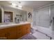 Bathroom featuring dual sinks, a glass-enclosed shower/tub combo, and classic tile details at 114 W Adams St # 907, Phoenix, AZ 85003