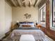 Comfortable bedroom features an exposed concrete ceiling and brick accent wall at 114 W Adams St # 907, Phoenix, AZ 85003