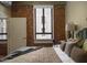 Inviting bedroom featuring exposed brick, a comfortable bed, and a bright window at 114 W Adams St # 907, Phoenix, AZ 85003