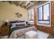 Comfortable bedroom features an exposed concrete ceiling and city views from large windows at 114 W Adams St # 907, Phoenix, AZ 85003