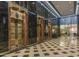 Vintage brass art deco elevator bank with marble walls and black and white floors in lobby at 114 W Adams St # 907, Phoenix, AZ 85003