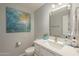 Stylish bathroom features a white vanity with double sinks and decorative art at 12537 N 76Th Pl, Scottsdale, AZ 85260