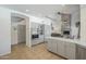 Bright, open kitchen with stainless steel appliances, island, and views to living area with stone fireplace at 12537 N 76Th Pl, Scottsdale, AZ 85260