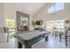 Bright living room featuring a fireplace, pool table, and high ceilings at 12537 N 76Th Pl, Scottsdale, AZ 85260