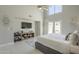 Spacious main bedroom with vaulted ceiling, fan, patio access, tv, and seating area at 12537 N 76Th Pl, Scottsdale, AZ 85260