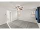 Large bedroom features neutral carpet, ceiling fan, and doors leading to the hall and the bathroom at 1255 N Banning --, Mesa, AZ 85205