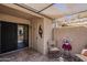 Cozy covered patio with tiled flooring, seating, and sliding glass door access to the indoors at 14300 W Bell Rd # 261, Surprise, AZ 85374