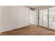 Bright bedroom boasts shuttered doors to the exterior with tan carpet and neutral walls at 14828 N Skokie Ct, Phoenix, AZ 85022