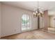Elegant dining room featuring a decorative chandelier, shuttered window and neutral carpet at 14828 N Skokie Ct, Phoenix, AZ 85022