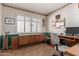 Office with paneled walls, built-in shelves, large shuttered window at 14828 N Skokie Ct, Phoenix, AZ 85022