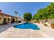 Backyard pool with lush landscaping and covered patio area at 14828 N Skokie Ct, Phoenix, AZ 85022