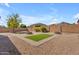 Desert landscaped backyard with stone firepit and block fence at 15564 W Mescal St, Surprise, AZ 85379