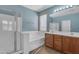 Bathroom features a walk-in shower, soaking tub, and double sink vanity at 15564 W Mescal St, Surprise, AZ 85379