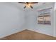 Cozy bedroom features a ceiling fan and a window with blinds, offering a comfortable and private retreat at 15564 W Mescal St, Surprise, AZ 85379