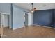 Spacious bedroom with a ceiling fan, wood floors, and decorative barn door at 15564 W Mescal St, Surprise, AZ 85379