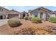 Inviting home exterior featuring desert landscaping, a tidy lawn, and a neutral color palette at 15564 W Mescal St, Surprise, AZ 85379