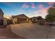Charming home featuring a spacious driveway, well-manicured landscaping, and an attached two-car garage at 15564 W Mescal St, Surprise, AZ 85379