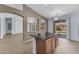Open kitchen island with granite countertop and view to the living area and back yard at 15564 W Mescal St, Surprise, AZ 85379