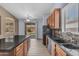 Kitchen features granite counters, wooden cabinets, tile backsplash, and black appliances at 15564 W Mescal St, Surprise, AZ 85379