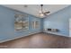 The sunny living room boasts hardwood floors, big windows, and blue walls at 15564 W Mescal St, Surprise, AZ 85379