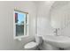 Clean powder room with a modern sink and toilet, complemented by a large window offering natural light at 16027 N 74Th Ln, Peoria, AZ 85382