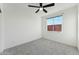 Bright bedroom with a ceiling fan, natural light, and neutral carpet is ready for your personal touch at 16027 N 74Th Ln, Peoria, AZ 85382