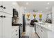 Modern kitchen featuring white cabinets, stainless steel appliances, and a sleek countertop island with breakfast bar at 16027 N 74Th Ln, Peoria, AZ 85382