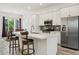 Stylish kitchen with a stainless steel refrigerator, white cabinets, and a view into the dining area at 16027 N 74Th Ln, Peoria, AZ 85382