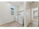 Bright laundry room with washer, dryer, storage shelf and natural light from window at 16027 N 74Th Ln, Peoria, AZ 85382