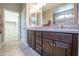 Bathroom featuring a double sink vanity and tile backsplash at 16913 W Holly St, Goodyear, AZ 85395