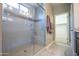 Glass enclosed shower featuring tile surround and a built-in bench at 16913 W Holly St, Goodyear, AZ 85395